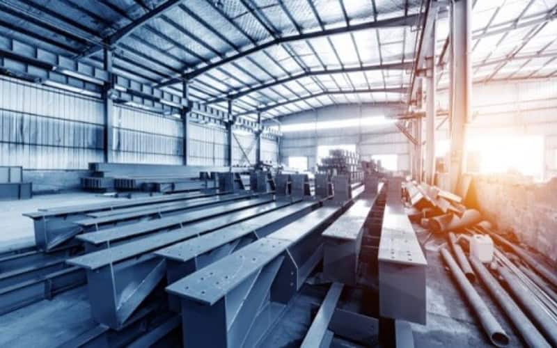 Interior of a steel manufacturing workshop with metal beams and equipment.